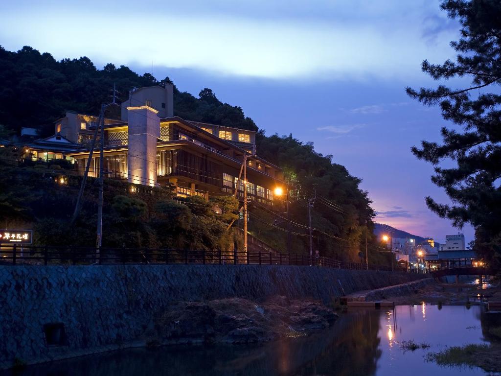 琴平町花坛酒店的河边的山丘上的一个晚上的建筑