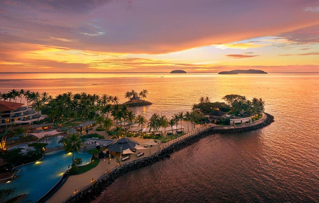 哥打京那巴鲁Shangri-La Tanjung Aru, Kota Kinabalu的日落时分在水上欣赏度假村的空中景色