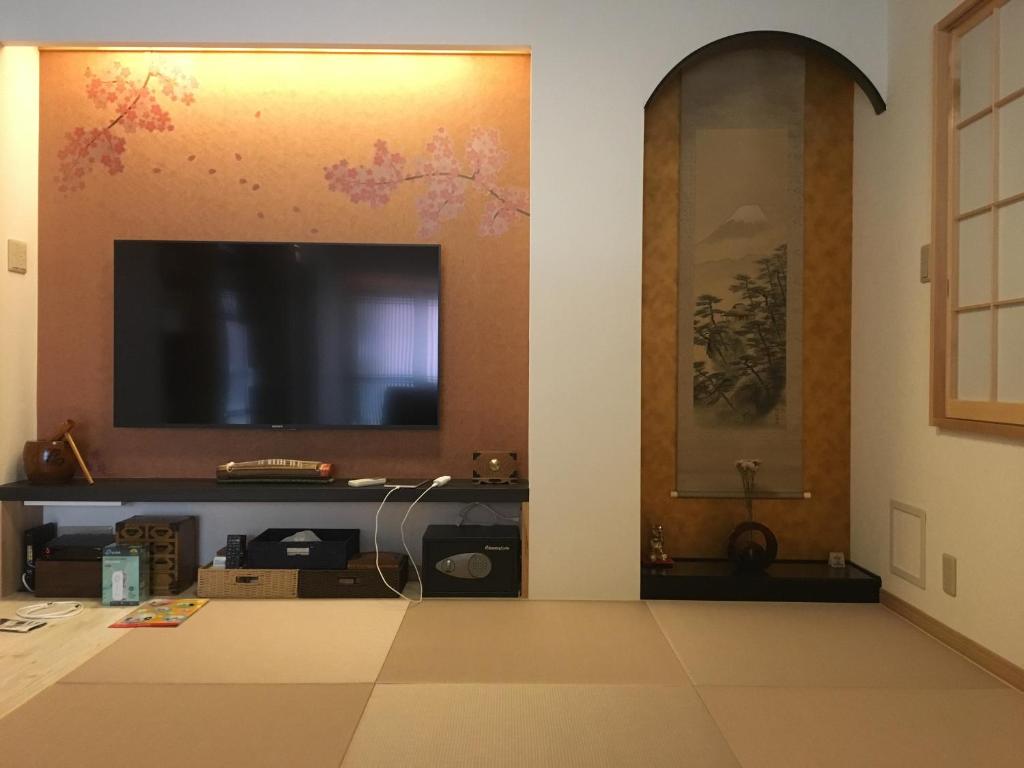 东京Tokyo inn Sakura An的客厅设有壁挂式平面电视。