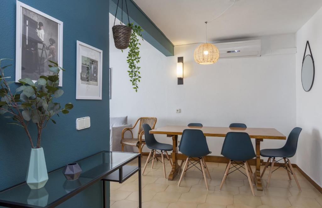 滨海托萨Apartments Mar de Tossa的一间带木桌和蓝色椅子的用餐室