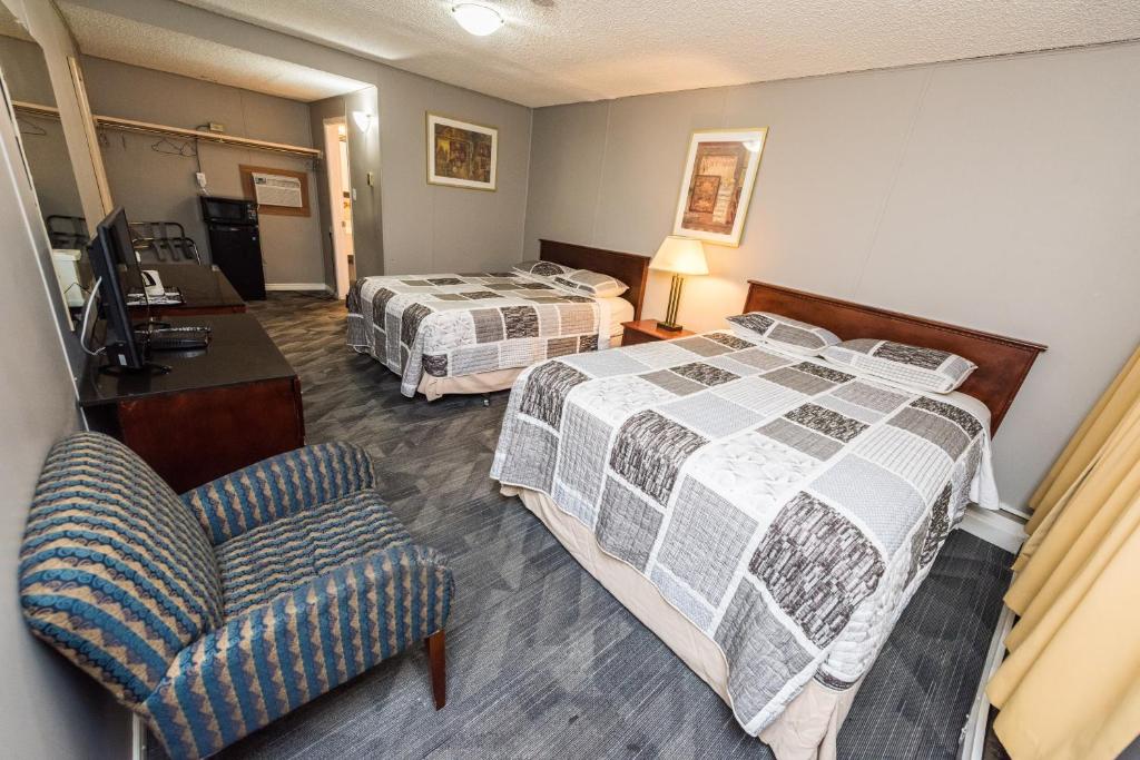 卡尔加里奥林匹亚酒店的酒店客房,配有两张床和椅子