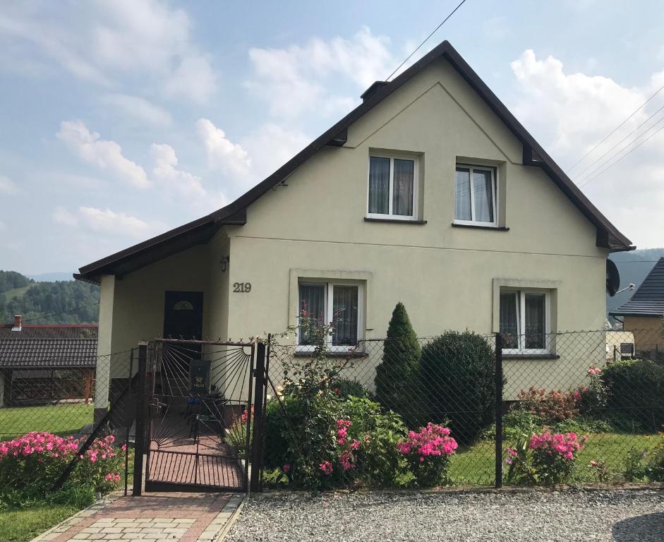 Sopotnia WielkaNoclegi na Wzgórzu Sopotnia Wielka的白色的房子,有门和鲜花