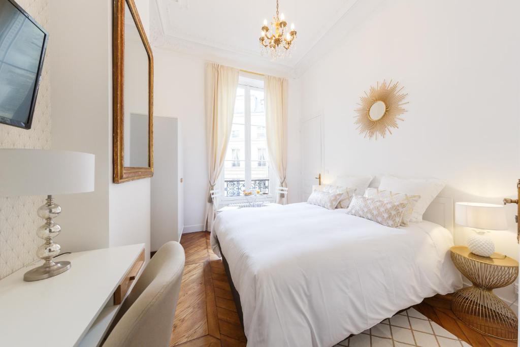 巴黎Maison de Lignières - Guest House - Paris quartier Champs-Elysées的白色卧室设有一张大床和镜子