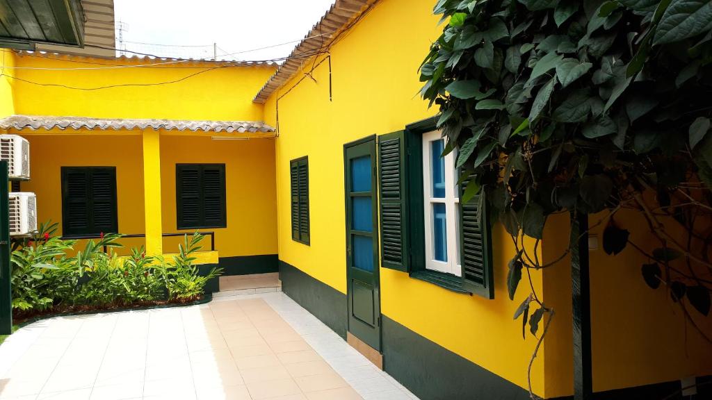 圣多美Residencialdes的黄色的房子,上面有绿色百叶窗