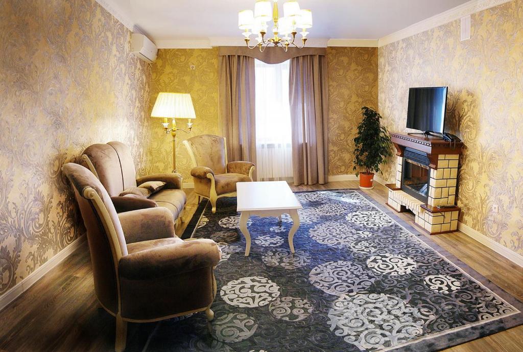 阿克托比Tumar Hotel的客厅配有沙发椅和电视