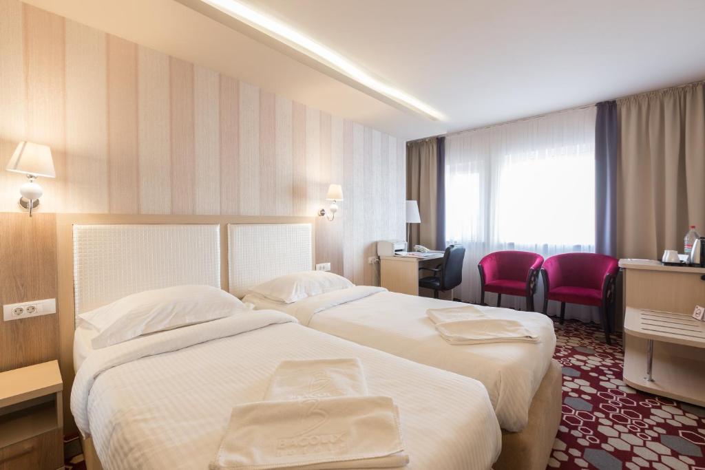 克拉约瓦Bacolux Craiovita Hotel & Events, Craiova的酒店客房配有两张床和一张书桌
