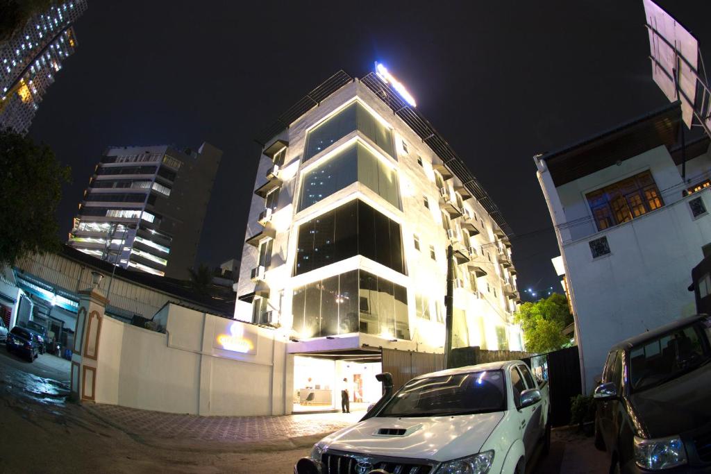 科伦坡City Hotel Colombo 02的夜间停在大楼前的白色汽车