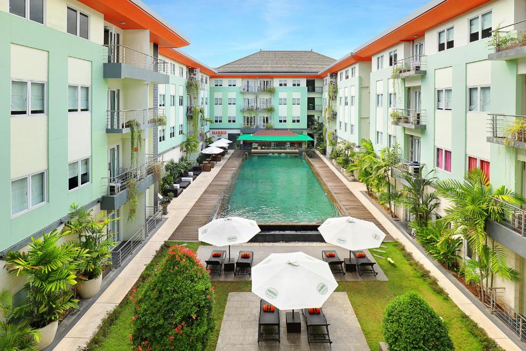 库塔HARRIS Hotel & Residences Riverview Kuta, Bali - Associated HARRIS的公寓大楼的空中景致,设有带遮阳伞的游泳池