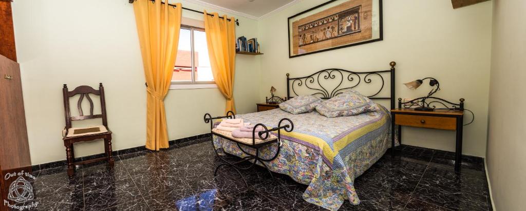 拉斯加莱塔斯Comfortable flat in El Fraile的卧室配有床、椅子和窗户。