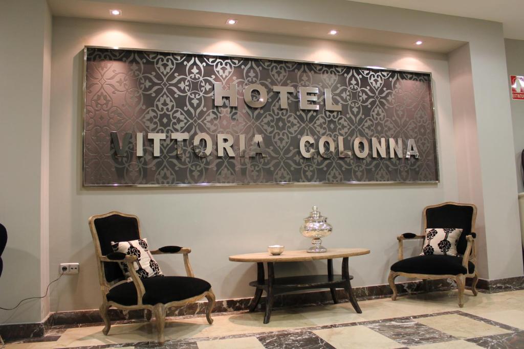 梅迪纳德里奥塞科Hospedium Hotel Vittoria Colonna的一间设有两把椅子和一张桌子的等候室