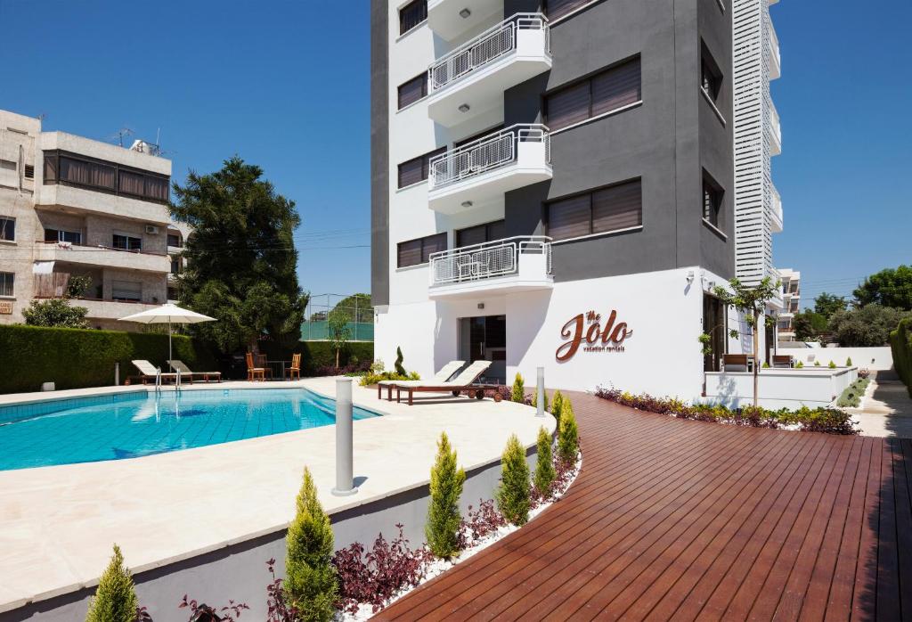 利马索尔The Jolo的一个带游泳池和大楼的公寓