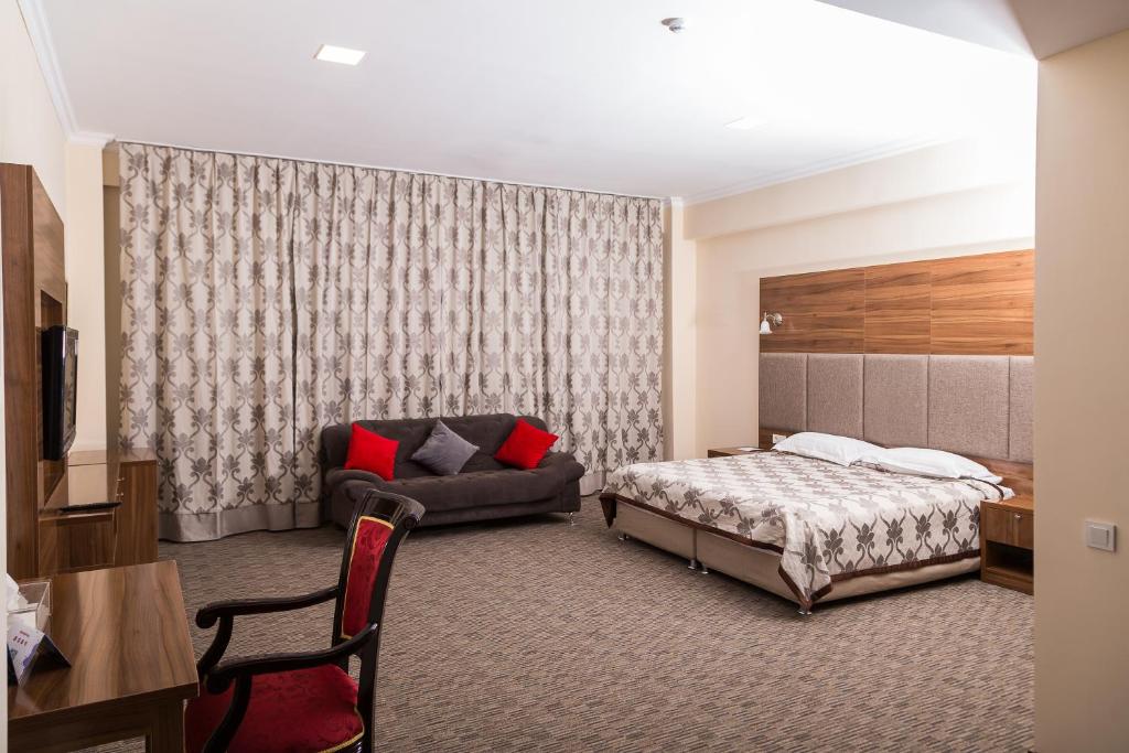 阿拉木图欧亚大酒店 的酒店客房,配有床和沙发