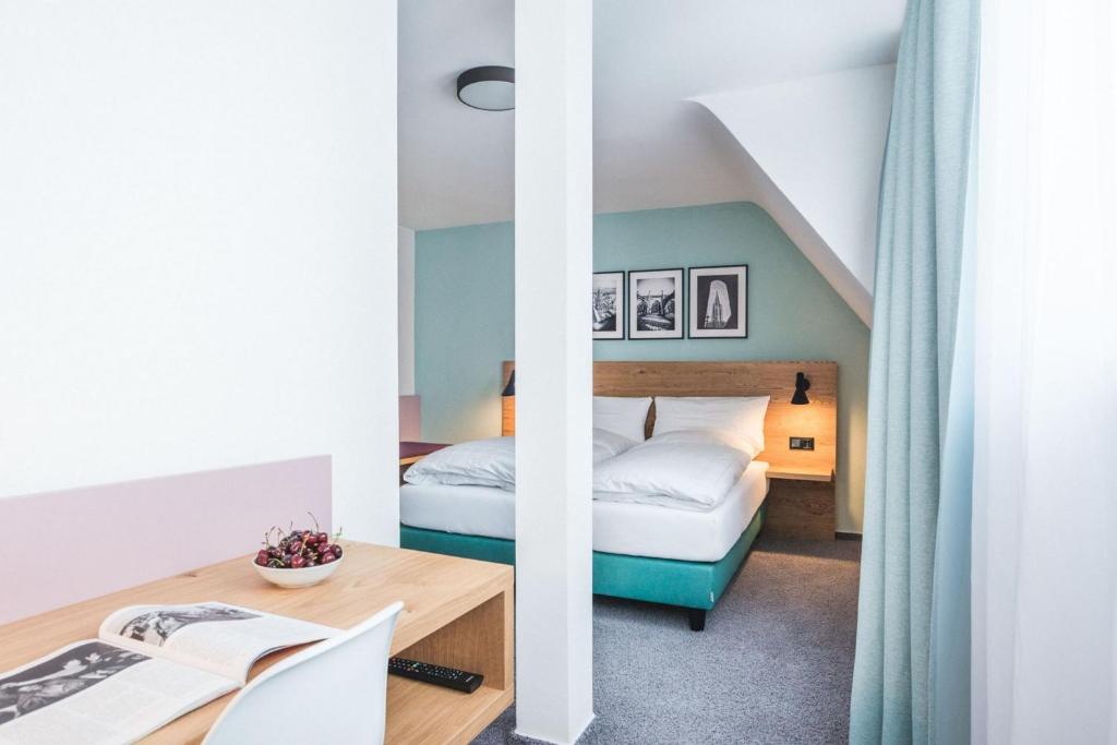 乌尔姆乌尔姆明斯特酒店的配有一张床和一张书桌的酒店客房