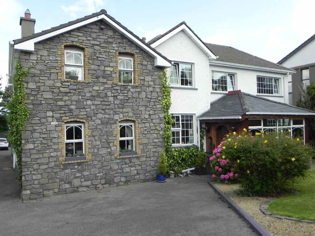 斯莱戈Pearse Lodge的车道上一座石头建筑的房子