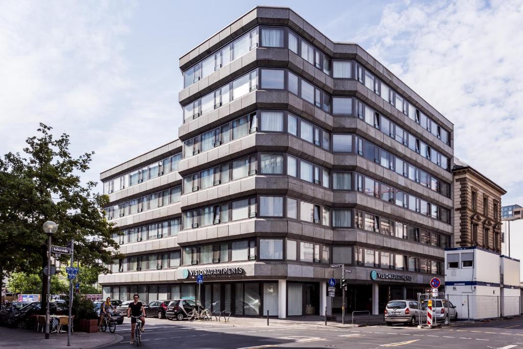 美因河畔法兰克福VISIONAPARTMENTS Gutleutstrasse - contactless check-in的一条城市街道上高大的灰色建筑