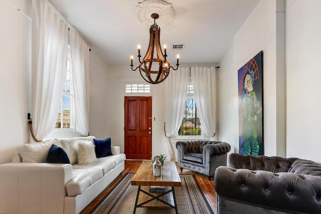 新奥尔良Modern Victorian House With Relaxing Courtyard的客厅配有白色沙发和吊灯。