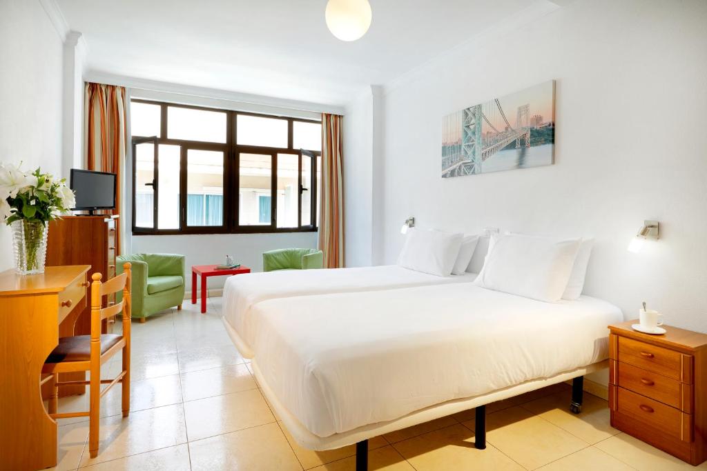 大加那利岛拉斯帕尔马斯Crisol Faycán的卧室配有一张白色大床和一张书桌