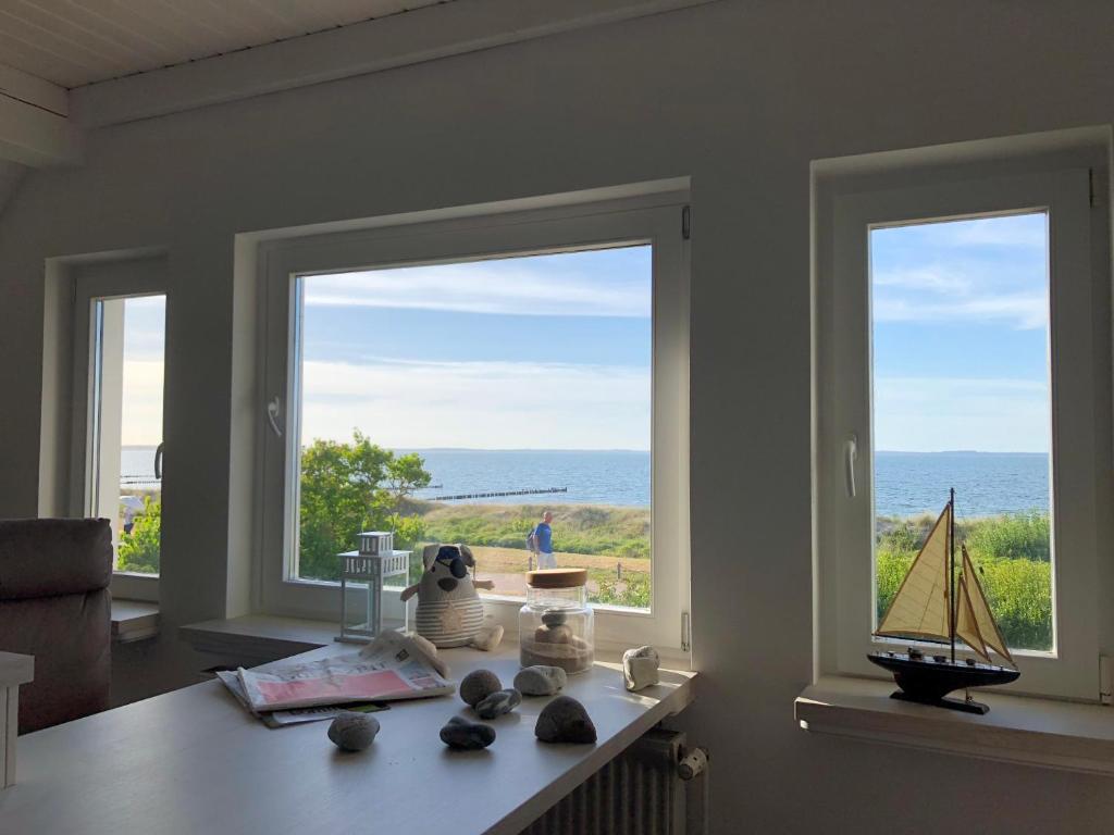 格洛韦Ferienwohnung Fritzi的客房设有2扇窗户和一张桌子,享有海景。