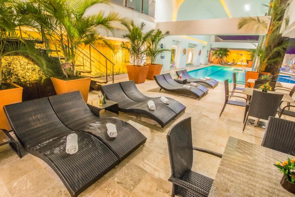 比亚维森西奥GHL Hotel Grand Villavicencio的酒店大堂设有椅子和游泳池