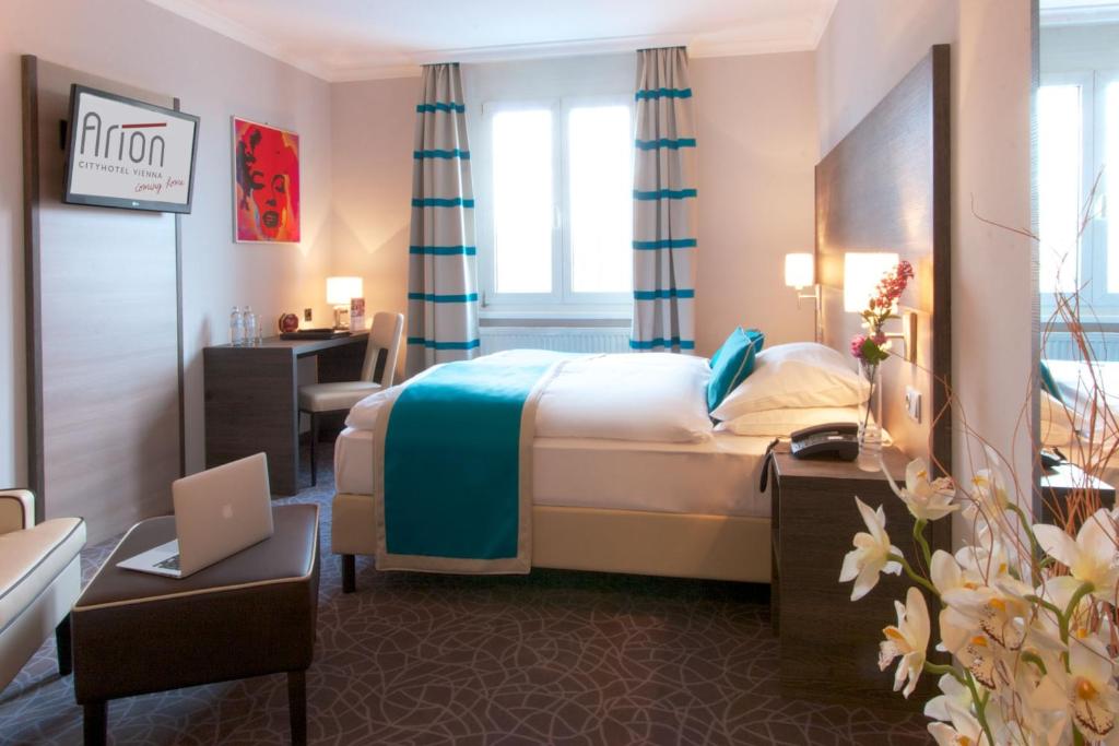 维也纳维也纳奥地利流行公寓酒店的酒店客房配有一张床、一张书桌和一台笔记本电脑