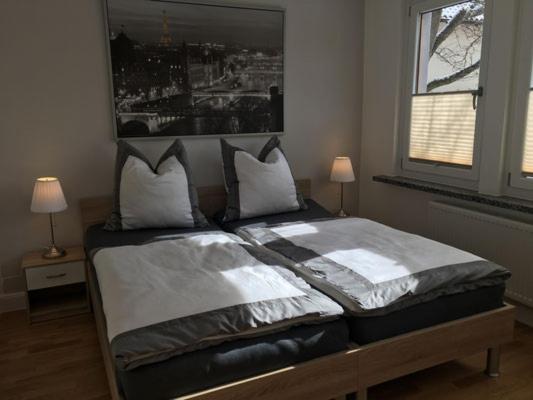 海尔巴德海利根斯塔特Zimmervermietung Hofmeister的卧室内的一张床位,配有两盏灯和一扇窗户