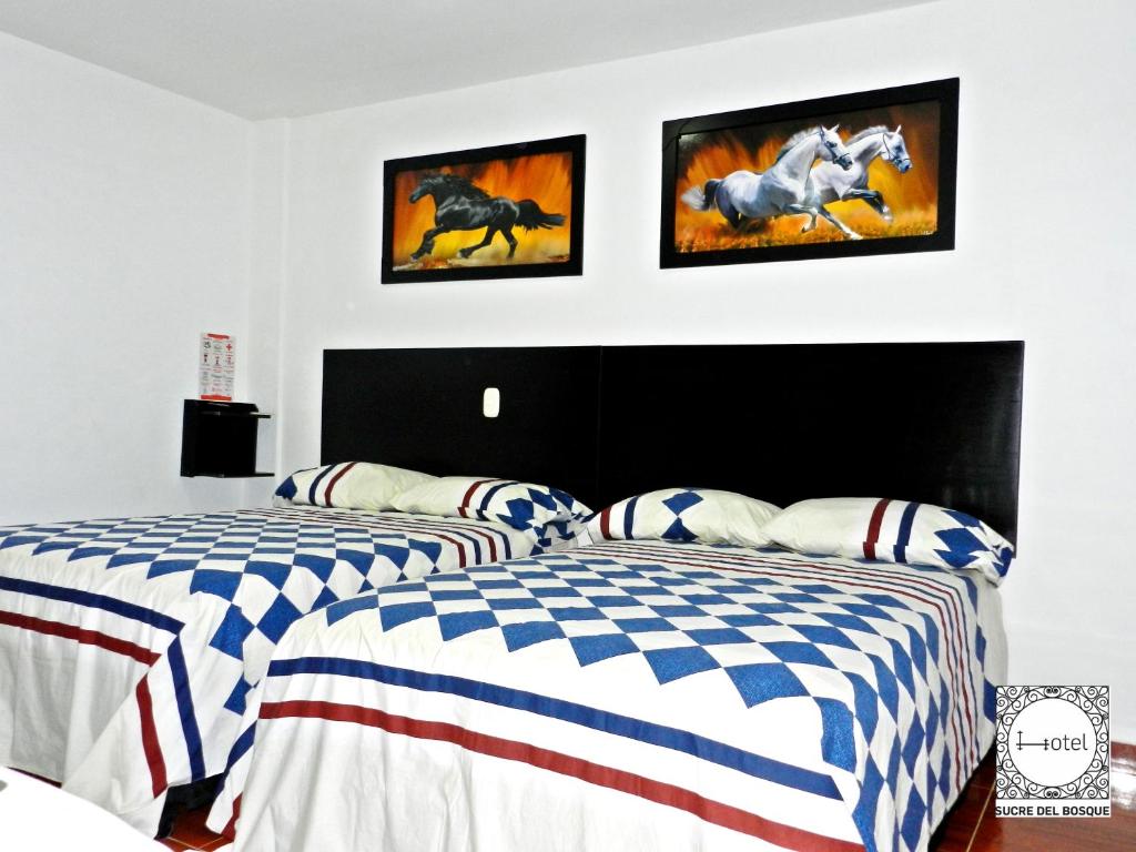 帕尔米拉Hotel Sucre Del Bosque的卧室设有两张床,配有美国国旗