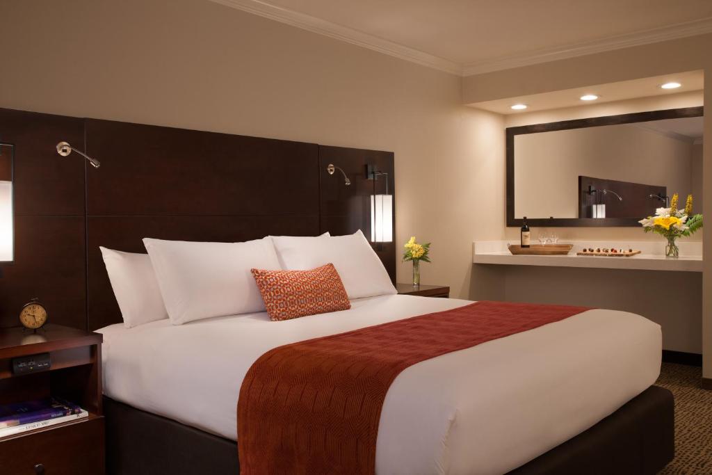 安克雷奇安克雷奇湖畔酒店的卧室配有一张大白床和大镜子