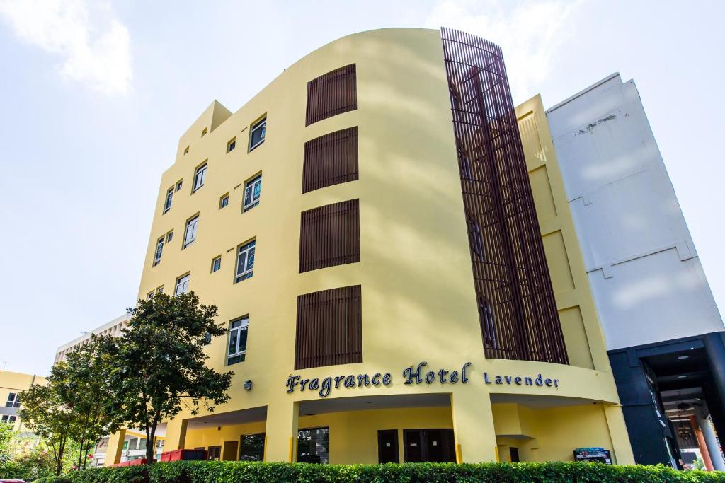 新加坡Fragrance Hotel - Lavender的黄色的建筑,上面有紧急放血标志