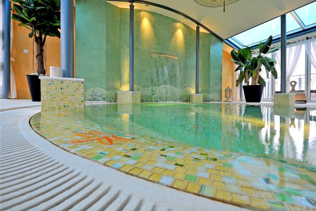 蒂宾根Boutiquehotel La Casa的一座大楼内一座带马赛克地板的游泳池