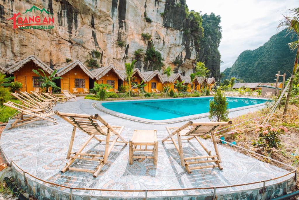 宁平Trang An Valley Bungalow的一个带游泳池和山脉的度假胜地