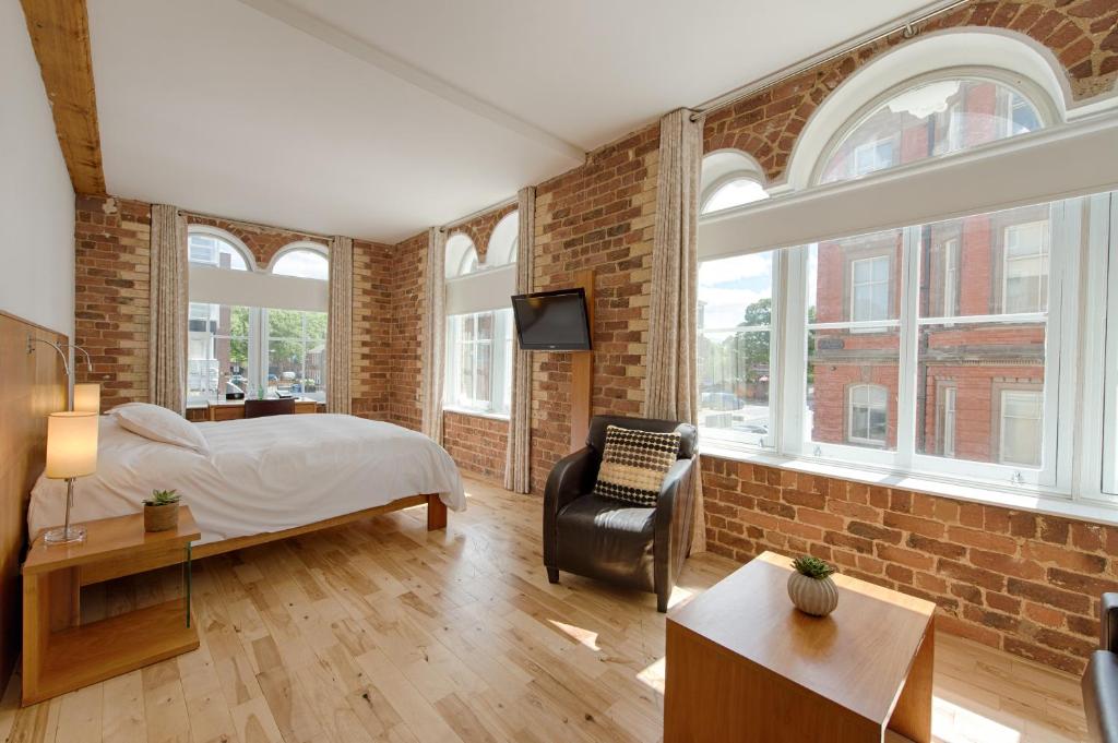 利物浦希望街设计酒店的一间卧室设有一张床和砖墙