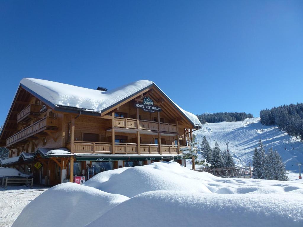 马尼戈冷杉健康美食酒店餐厅的一座大木结构建筑,被雪覆盖