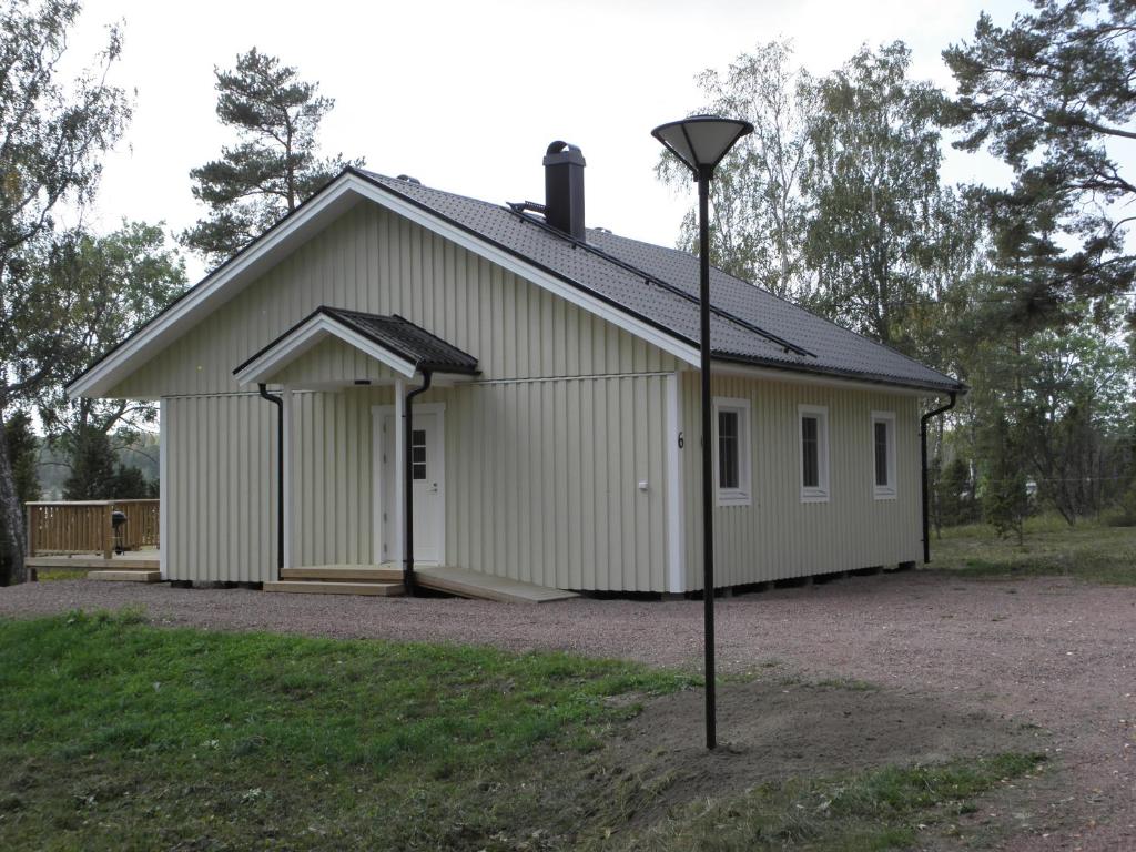 FinströmSöderö stugby的前面有一根灯杆的白色大建筑