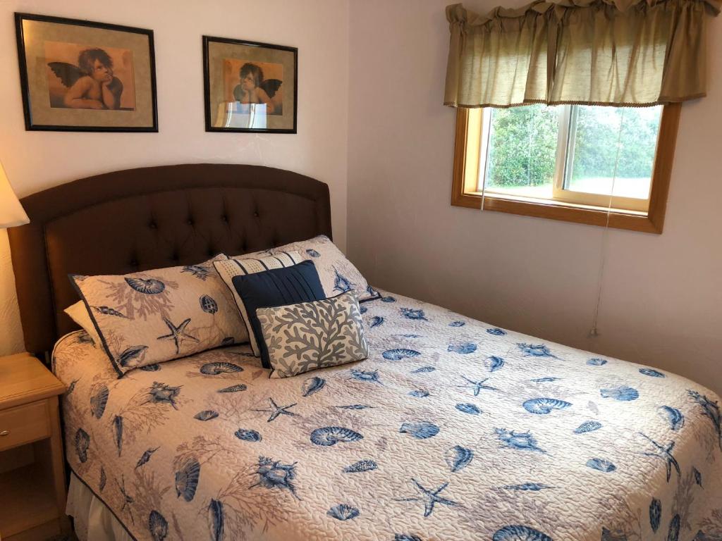 洋滨市威斯特里汽车旅馆的一间卧室配有一张带蓝色花卉棉被的床