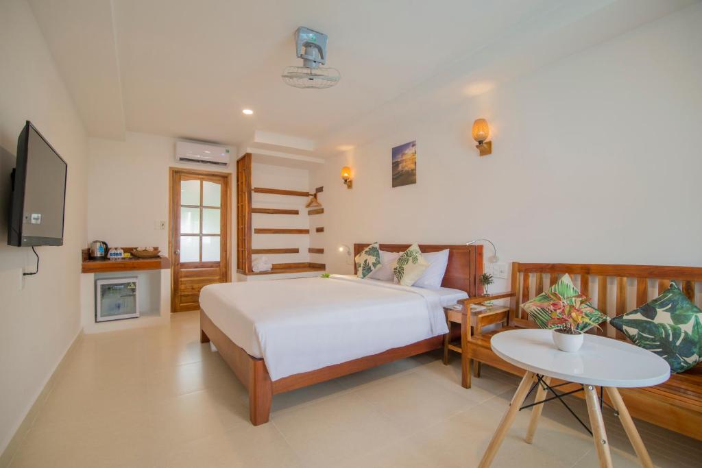 富国Palma Resort的一间卧室配有一张床、一张桌子和一台电视。