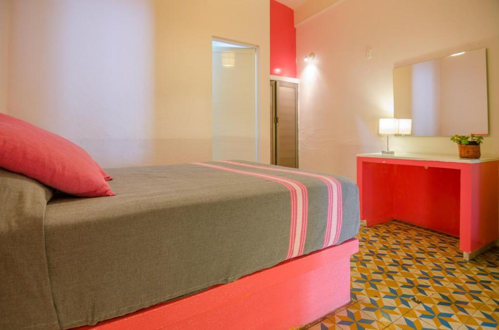 瓦哈卡市唐巴勃罗旅馆的一间卧室配有一张床和一个带镜子的梳妆台