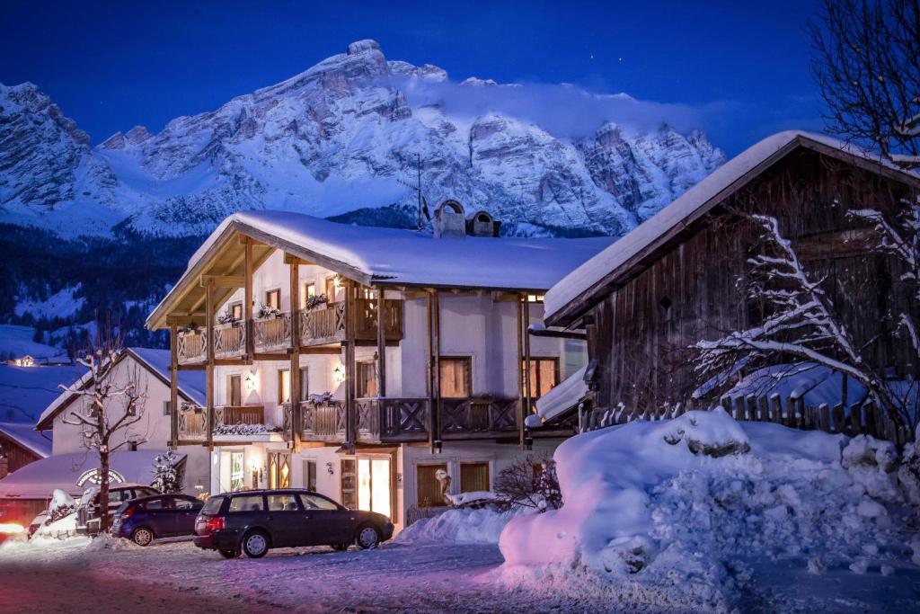 拉维拉Residence Sas Vanna的雪中与山间在夜间的房子