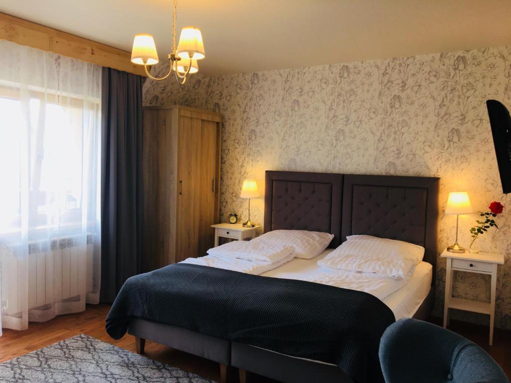 尤格Apartamenty w Jurgowie Świstokówka的卧室配有带白色枕头的大床