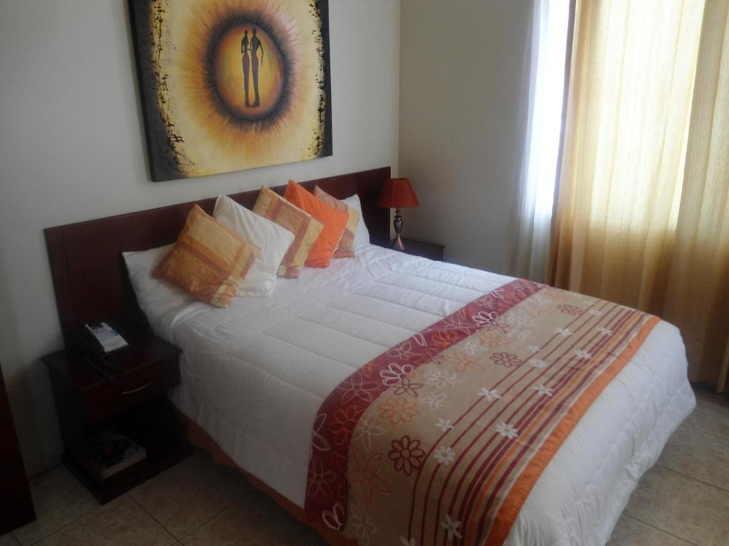 瓜亚基尔天空套房酒店的一间卧室配有一张带枕头的大床