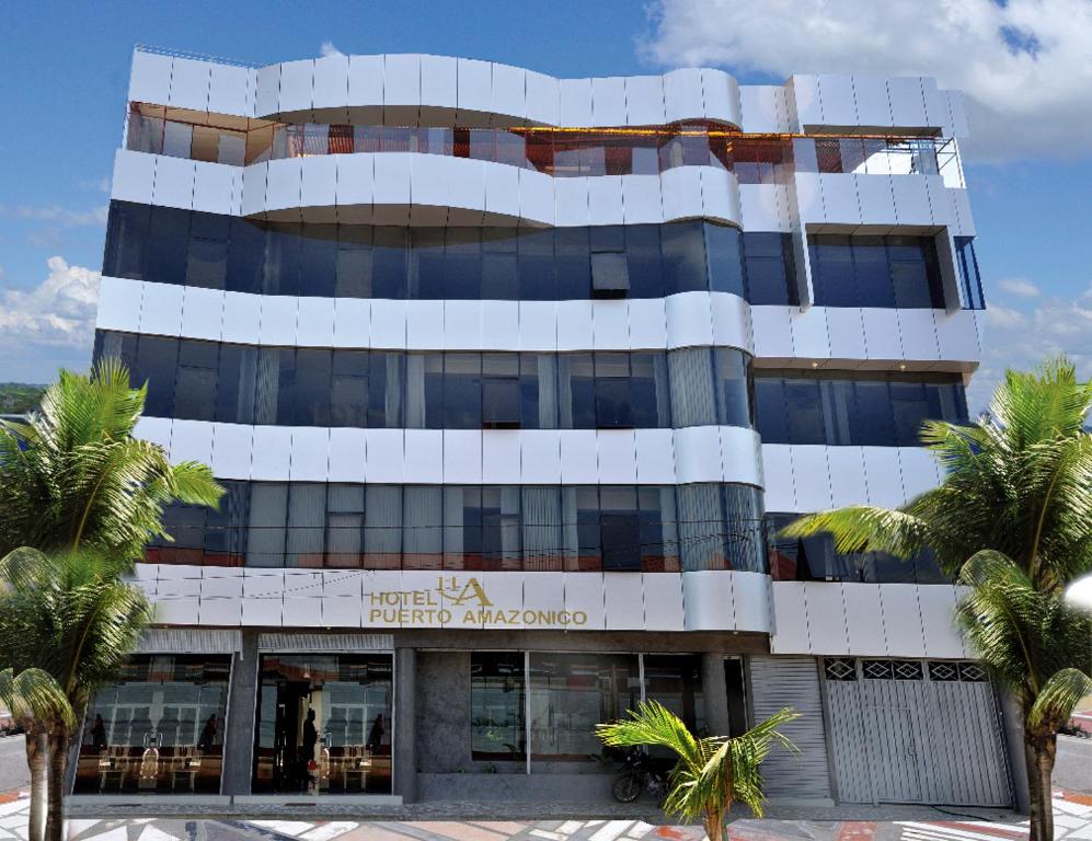 马尔多纳多港Hotel Puerto Amazonico的一座棕榈树环绕的大建筑
