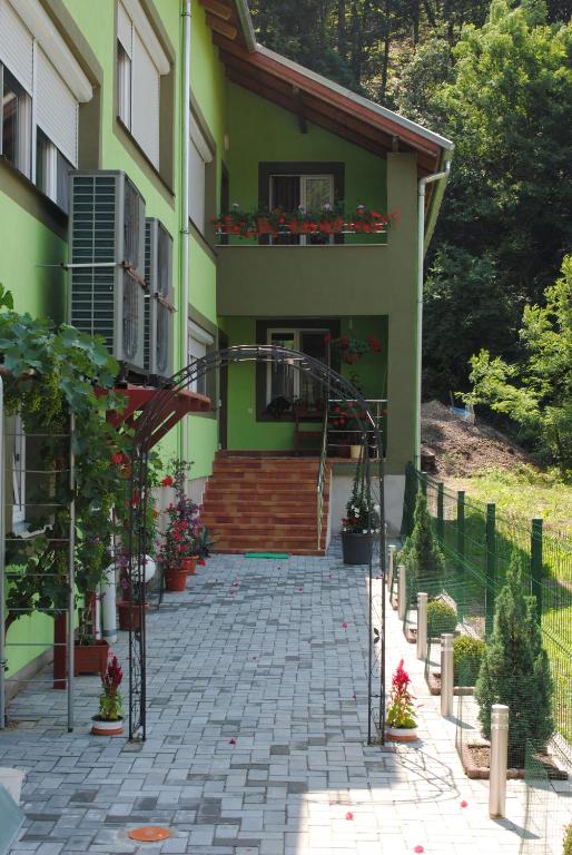 莫内亚萨Casa Flori de Nuc的绿色的房子,设有楼梯和阳台