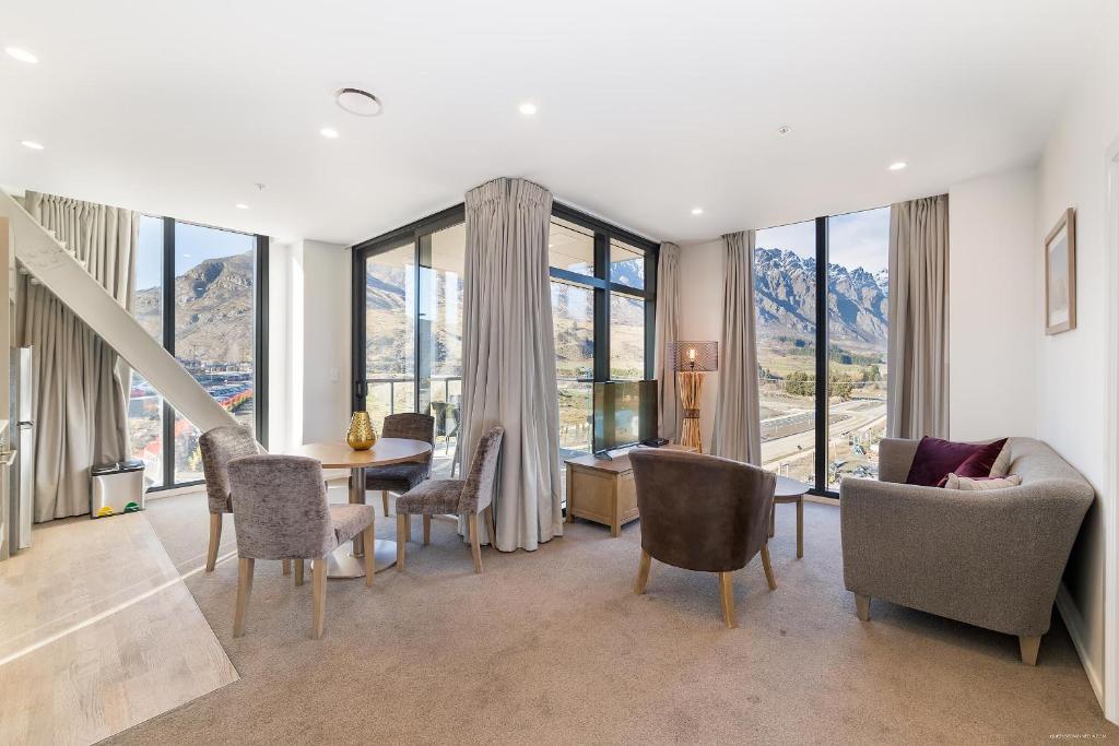 皇后镇Executive 2 Bedroom Apartment Remarkables Park的客厅配有桌椅和窗户。