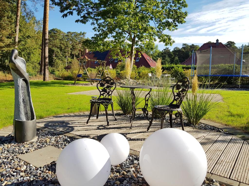 宾茨祖尔阿尔腾博斯特普罗拉酒店的花园内摆放着两把椅子,地面上摆放着白色鸡蛋