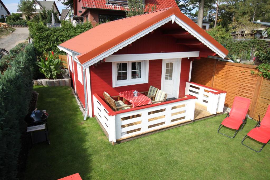普劳西Blockbohlenhaus Plau am See的草坪上红色的屋顶棚