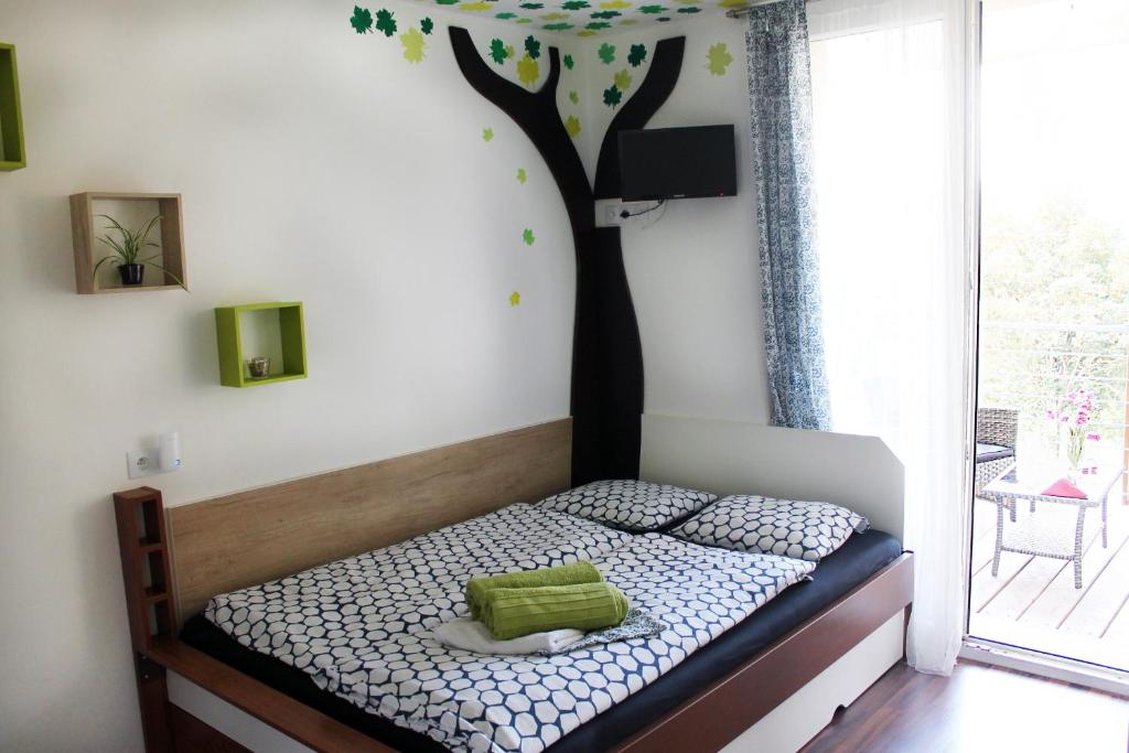 斯托泽克Šumaváček - Exclusive的卧室配有一张床铺,墙上挂着一棵树