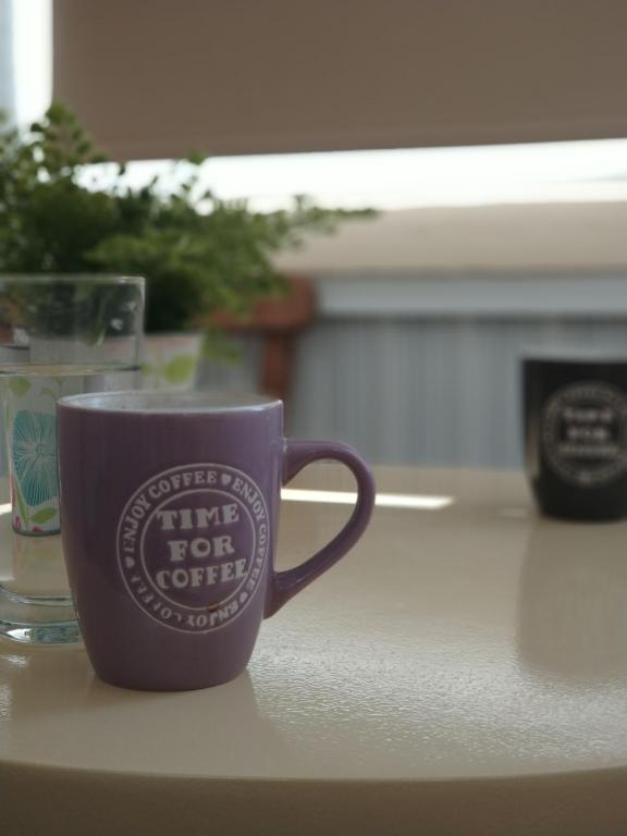 拉纳卡Elena Apartmen的坐在桌子上的紫色咖啡杯