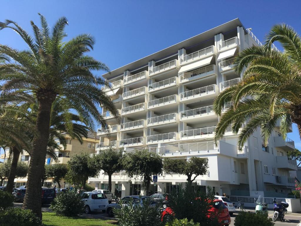 朱利亚诺瓦FRONTE MARE-CENTRALE-Riviera Palace-Giulianova-Apartment-nei mesi di Giugno Luglio e Agosto Prenotazioni solo da Sabato a Sabato的棕榈树大型白色公寓