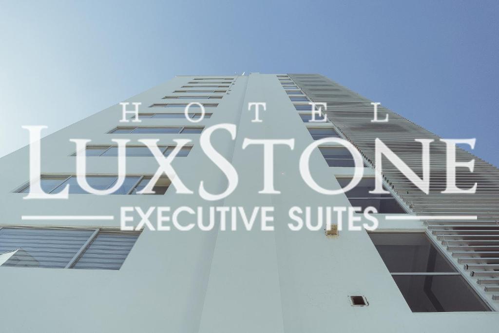拉巴斯Luxstone Executive & Suites的一座高楼,上面写着伦敦行政套房
