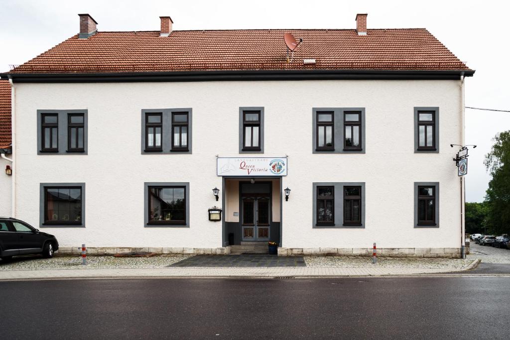 StadtilmLandgasthaus Queen Victoria的白色的建筑,带有棕色的屋顶