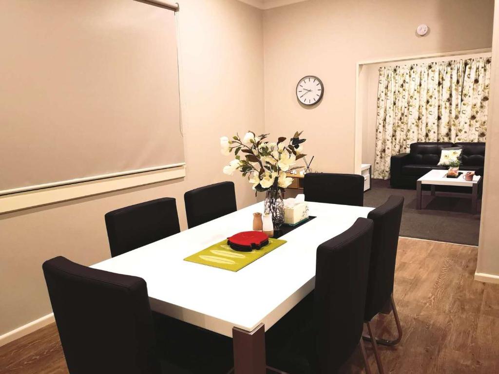 奥玛鲁Home Sweet Home的一间配备有白色桌子和黑色椅子的用餐室